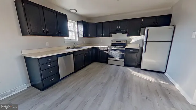 a kitchen with a refrigerator and a stove top oven