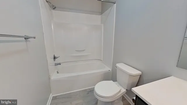 a white toilet and tub sitting next to a bathroom sink