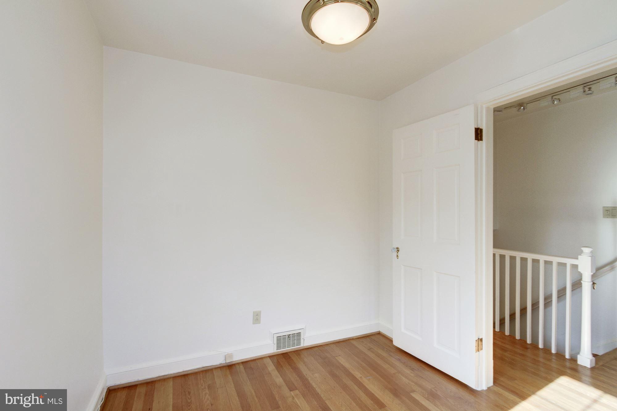 7015 Exfair Road Bethesda, MD 20814 - Photo 22 of 30 a view of a room with wooden floor and white walls