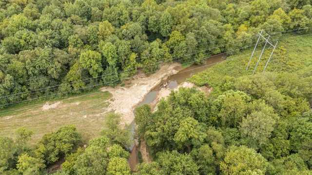 an aerial view of residential houses with outdoor space and trees
