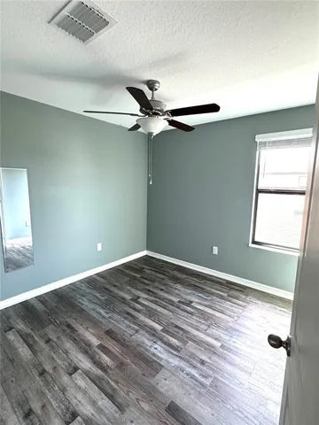 a view of a hallway with wooden floor and stairs