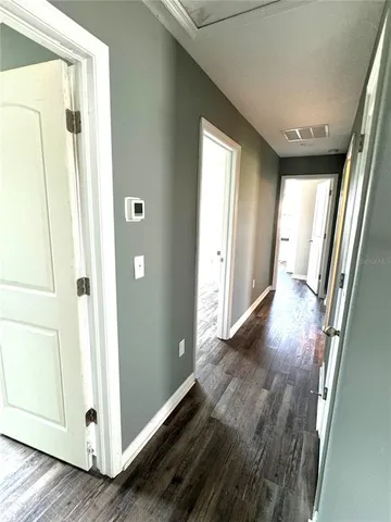 a view of a hallway with wooden floor and staircase