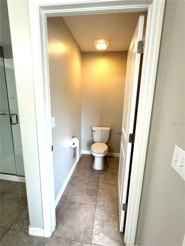 a white toilet sitting next to a white wall