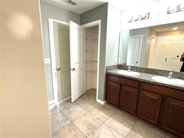 a bathroom with a granite countertop sink a mirror and a bathtub