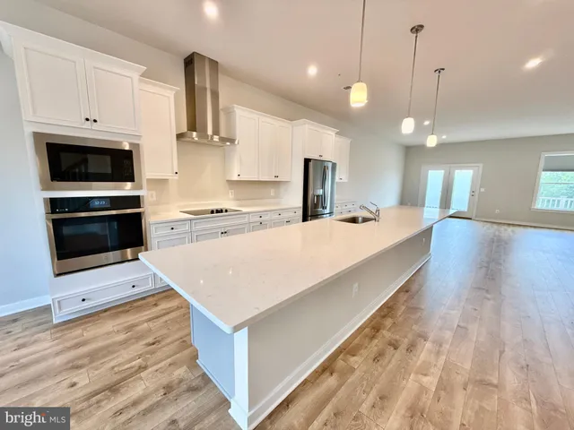 a large kitchen with kitchen island a sink stainless steel appliances and cabinets