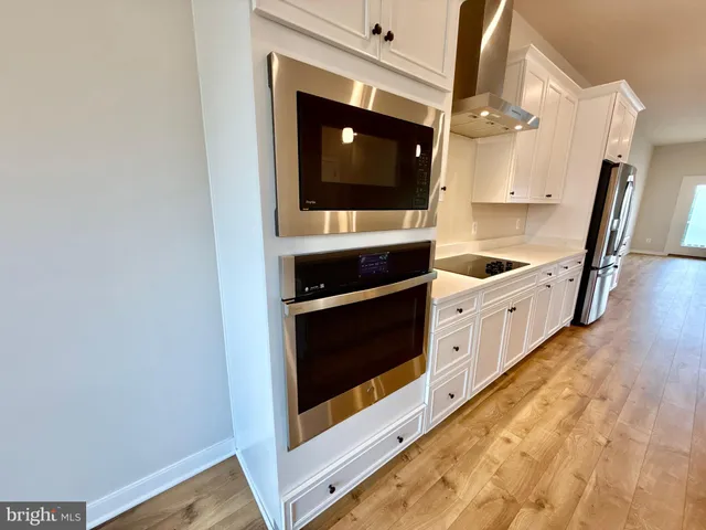 a kitchen with stainless steel appliances a stove and a microwave