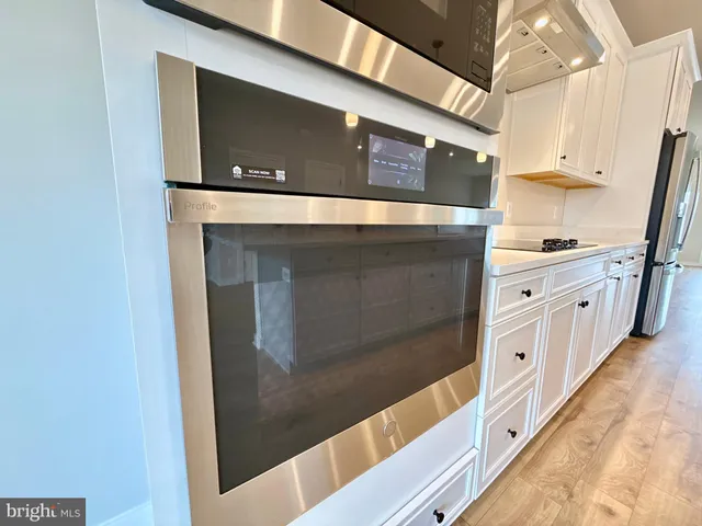 a kitchen with stainless steel appliances granite countertop a refrigerator and a stove