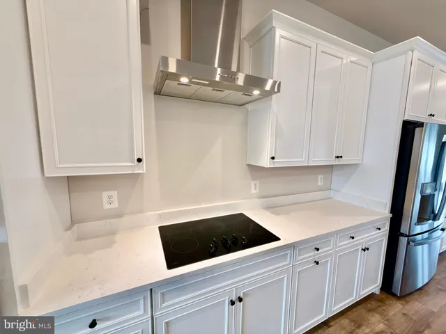 a kitchen with granite countertop white cabinets and stainless steel appliances