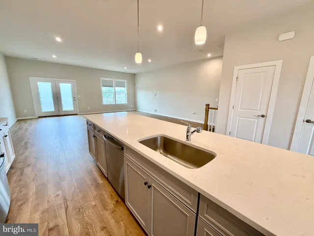 a large kitchen with kitchen island a sink stainless steel appliances and a window