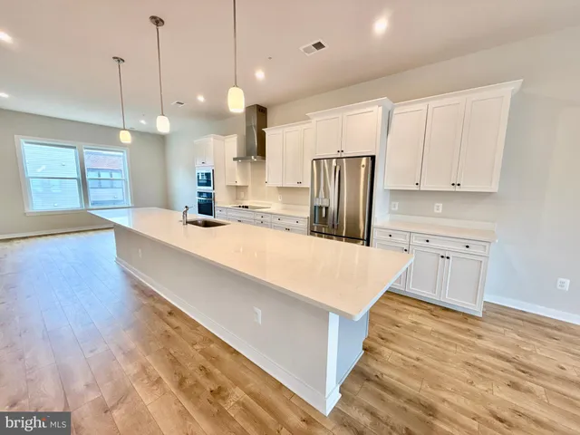a large kitchen with kitchen island a sink a center island stainless steel appliances and a center island