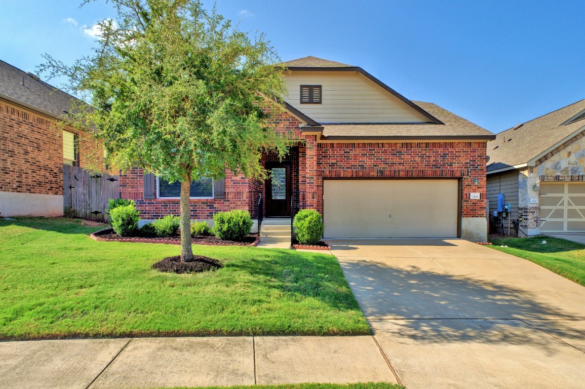 a front view of a house with a yard and garage