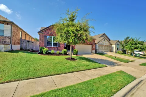 a front view of a house with a yard and potted plants