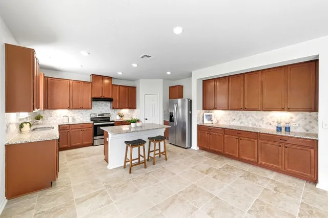 a kitchen with a stove a sink a microwave and a refrigerator