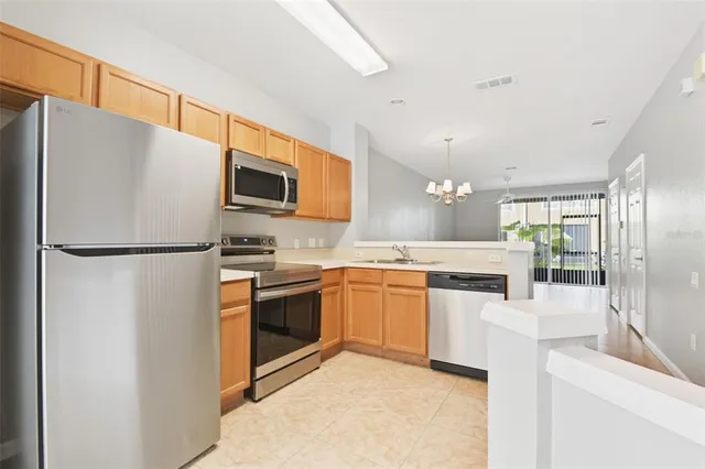 a kitchen with stainless steel appliances granite countertop a refrigerator a stove and a sink