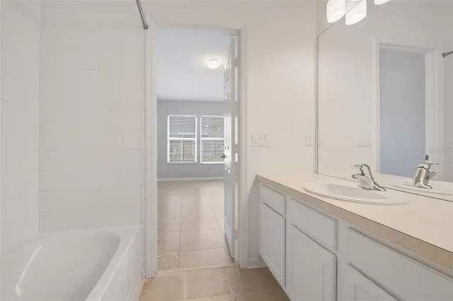 a bathroom with a tub sink and mirror
