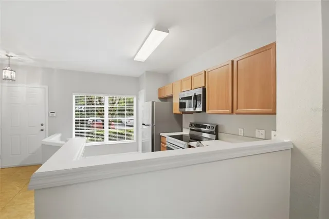 a kitchen with stainless steel appliances a sink and a large window