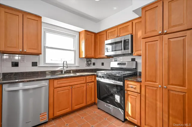 a kitchen with stainless steel appliances granite countertop a sink stove and refrigerator
