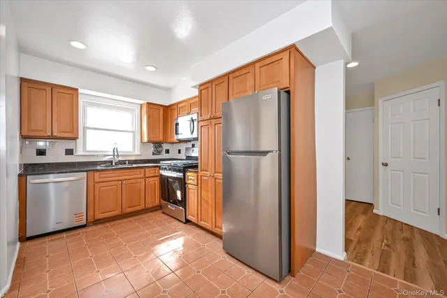 a kitchen with stainless steel appliances granite countertop a refrigerator and a stove top oven
