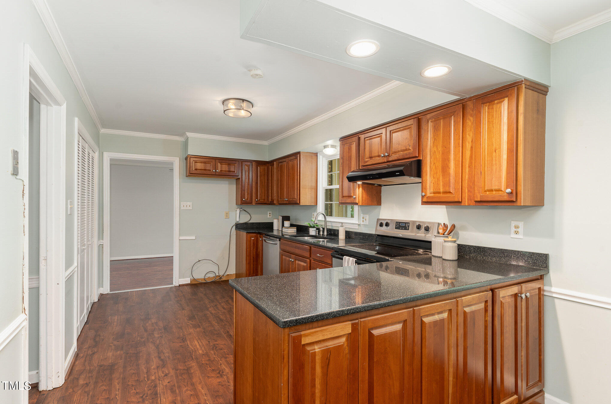 4100 Stranaver Place Raleigh, NC 27612 - Photo 6 of 43 a kitchen with granite countertop a sink a counter space appliances and cabinets