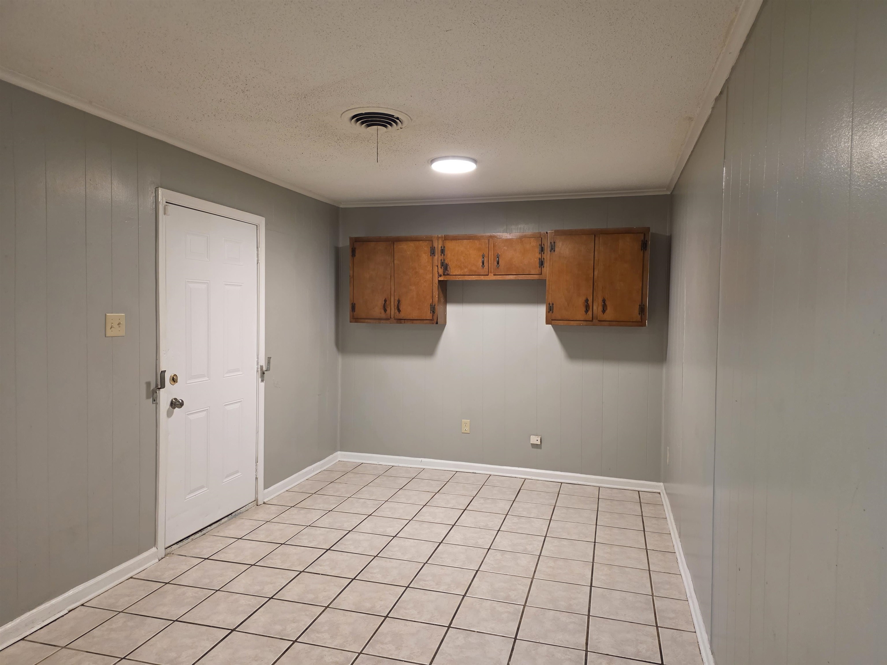 4573 Appleville Street Memphis, TN 38109 - Photo 14 of 22 Laundry area with wooden walls, a textured ceiling, crown molding, and light tile patterned flooring