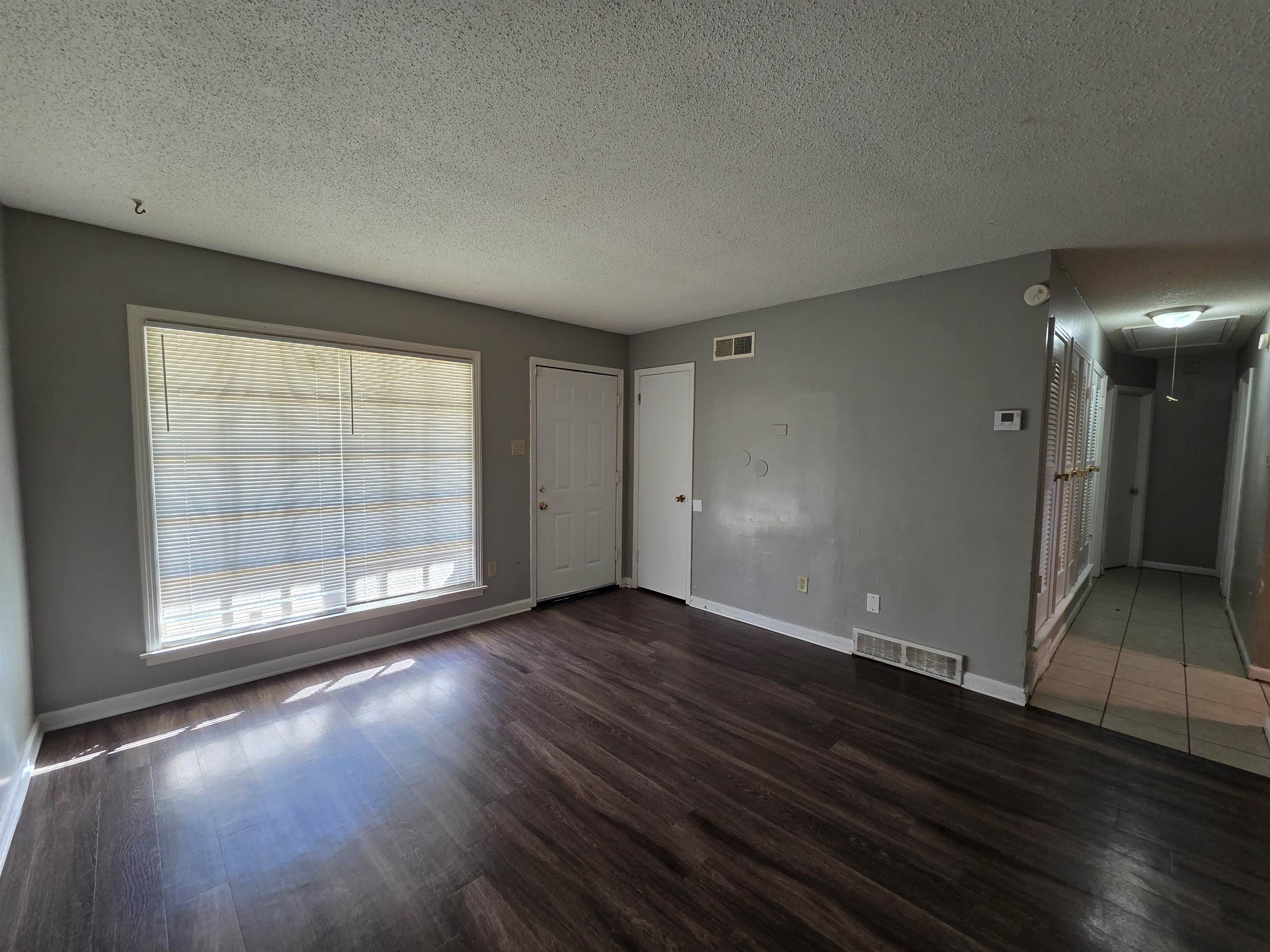 4573 Appleville Street Memphis, TN 38109 - Photo 6 of 22 Unfurnished living room featuring attic access, a textured ceiling, and wood finished floors