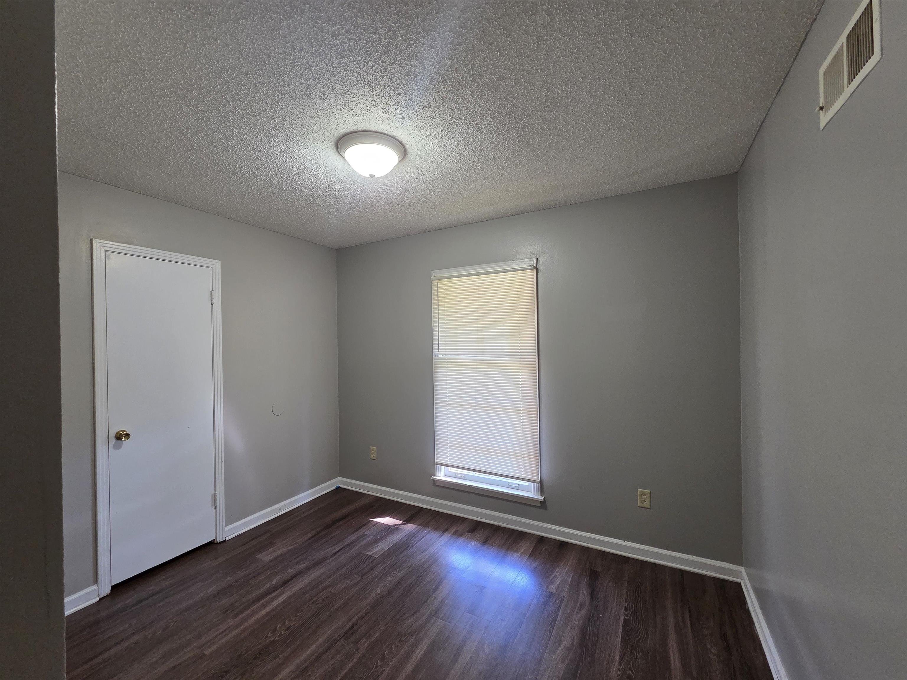 4573 Appleville Street Memphis, TN 38109 - Photo 7 of 22 Spare room with dark wood-type flooring and a textured ceiling