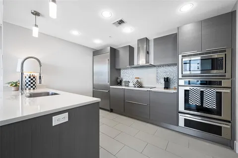 a kitchen with kitchen island granite countertop a stove and a sink