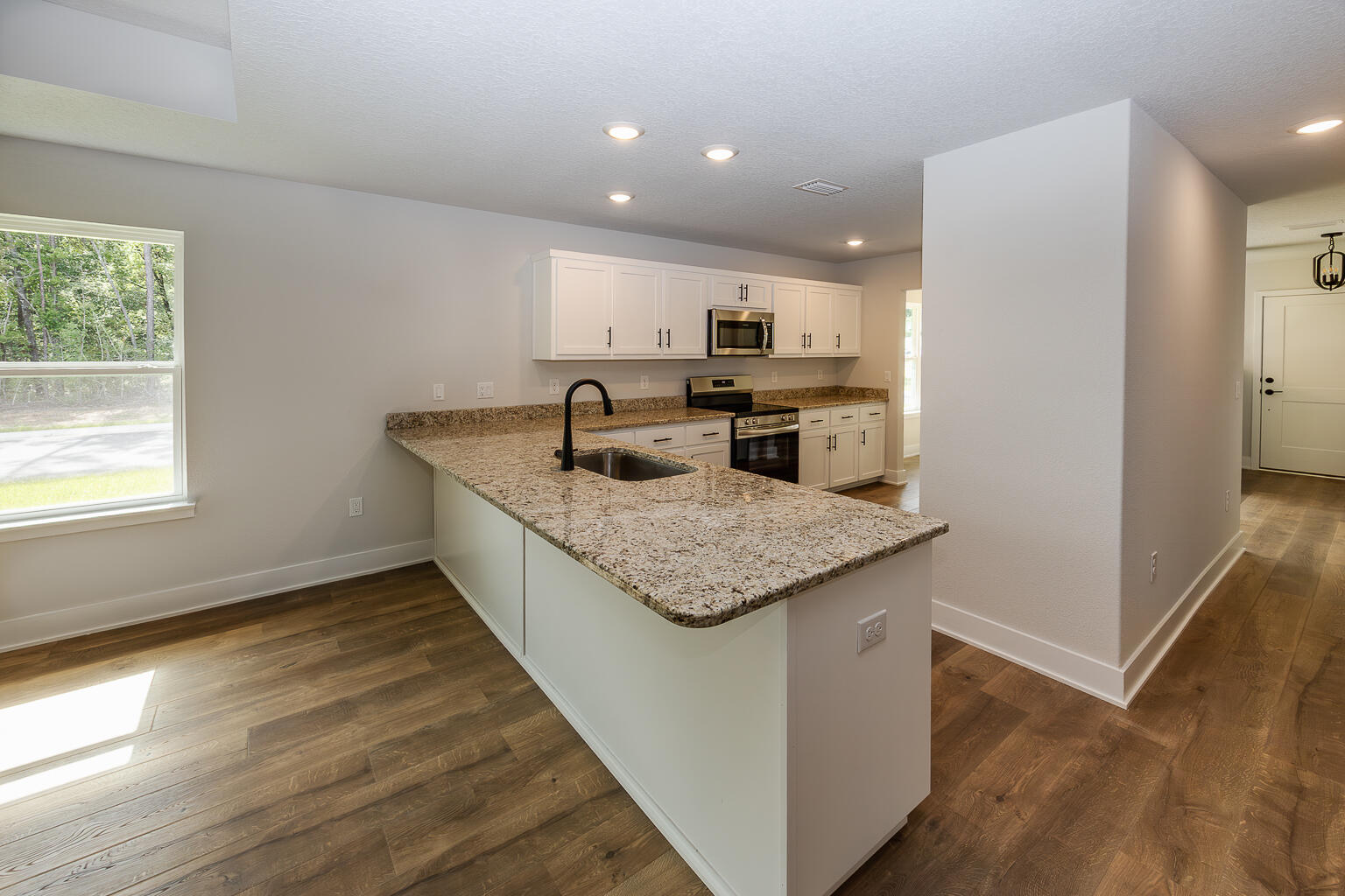 5303 Zenith Lane Milton, FL 32583 - Photo 5 of 21 a kitchen with a sink window and cabinets