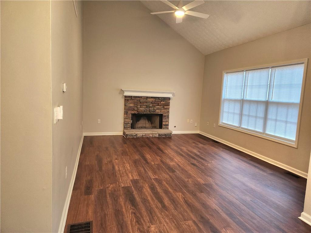 1645 Rushing River Way Suwanee, GA 30024 - Photo 17 of 38 an empty room with wooden floor fireplace and windows