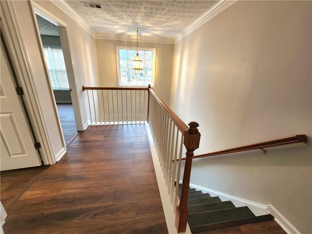 1645 Rushing River Way Suwanee, GA 30024 - Photo 19 of 38 a view of a hallway with wooden floor and staircase