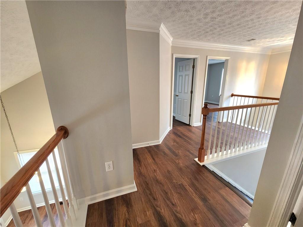 1645 Rushing River Way Suwanee, GA 30024 - Photo 21 of 38 a view of a hallway with wooden floor and staircase