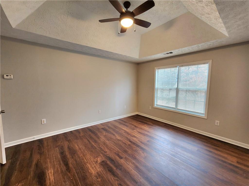 1645 Rushing River Way Suwanee, GA 30024 - Photo 24 of 38 an empty room with wooden floor a ceiling fan and windows