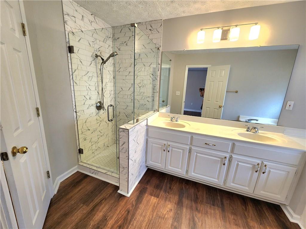 1645 Rushing River Way Suwanee, GA 30024 - Photo 26 of 38 a spacious bathroom with a double vanity sink and a mirror