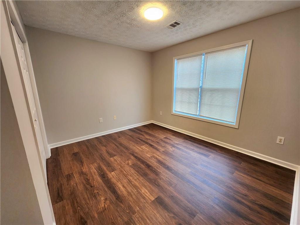 1645 Rushing River Way Suwanee, GA 30024 - Photo 27 of 38 an empty room with wooden floor and windows