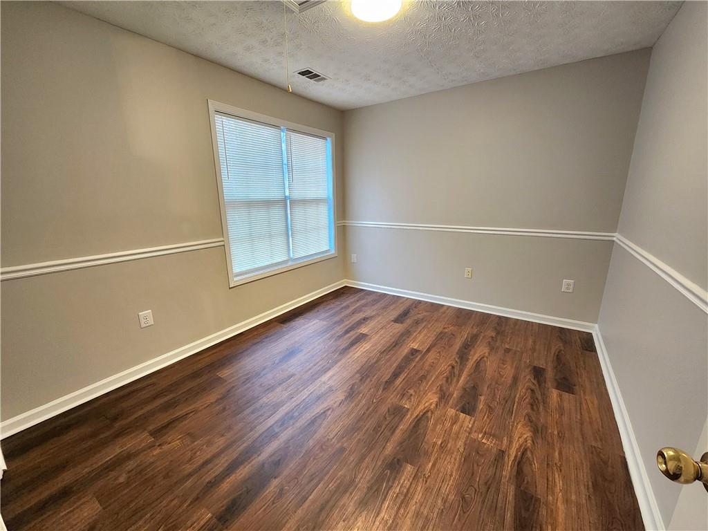 1645 Rushing River Way Suwanee, GA 30024 - Photo 28 of 38 an empty room with wooden floor and windows