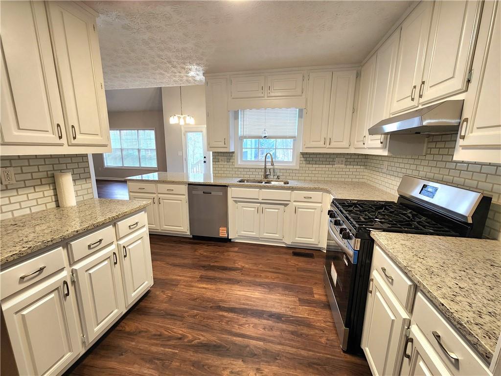 1645 Rushing River Way Suwanee, GA 30024 - Photo 4 of 38 a kitchen with stainless steel appliances granite countertop a stove sink and cabinets