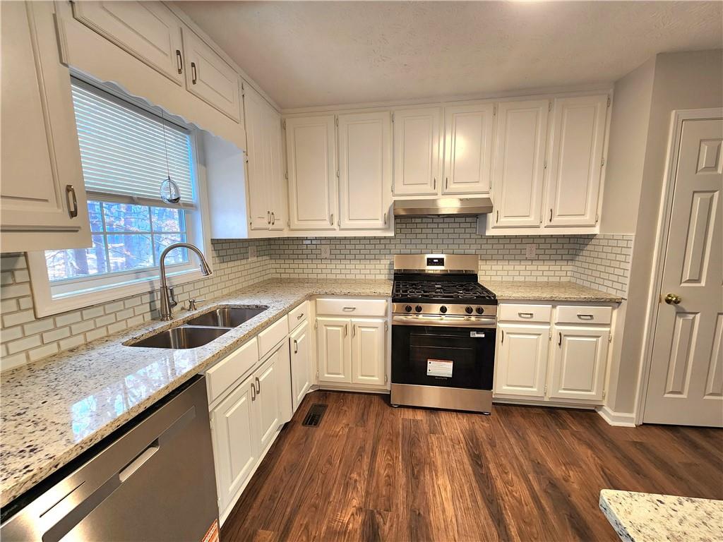 1645 Rushing River Way Suwanee, GA 30024 - Photo 5 of 38 a kitchen with granite countertop a sink stainless steel appliances and cabinets