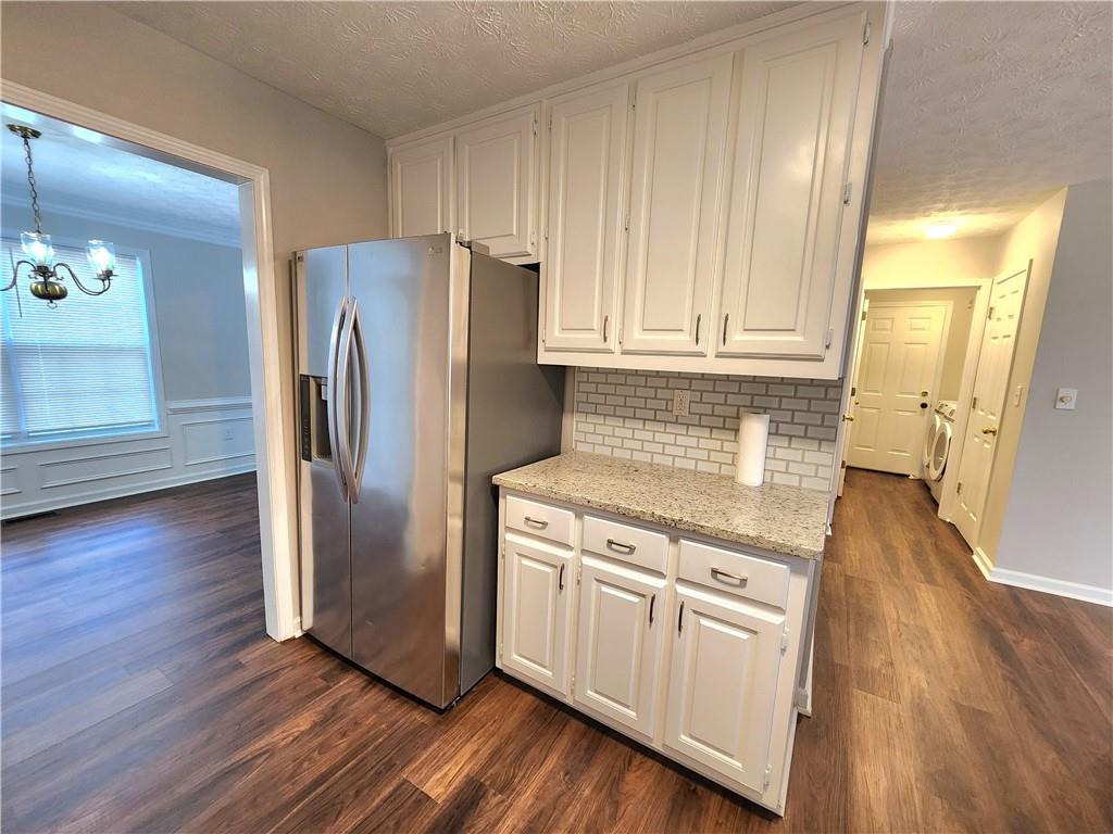 1645 Rushing River Way Suwanee, GA 30024 - Photo 6 of 38 a kitchen with wooden floors and white stainless steel appliances