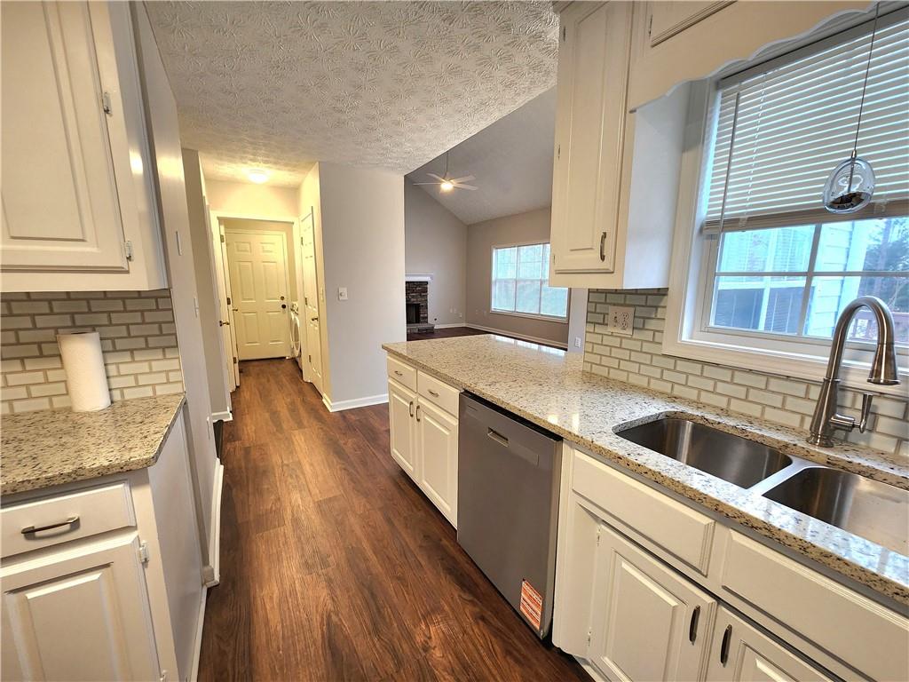 1645 Rushing River Way Suwanee, GA 30024 - Photo 7 of 38 a kitchen with a sink a counter top space cabinets stainless steel appliances and a window