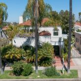 a view of a house with a yard and potted plants