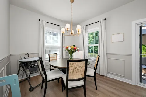 a dining room with furniture a chandelier and wooden floor