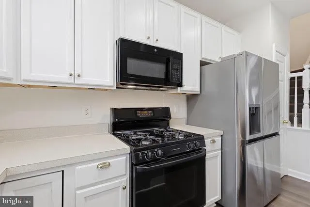 a kitchen with stainless steel appliances a stove a microwave and refrigerator