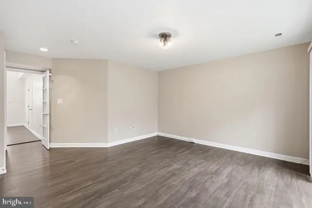 a view of an empty room with wooden floor