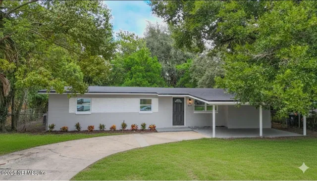 a front view of house with yard and trees in the background