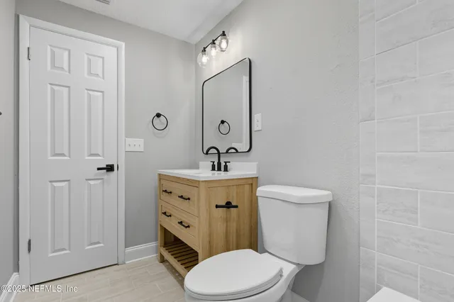 a bathroom with a toilet a sink a vanity and mirror