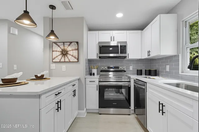 a kitchen with stainless steel appliances granite countertop a stove a sink and a microwave