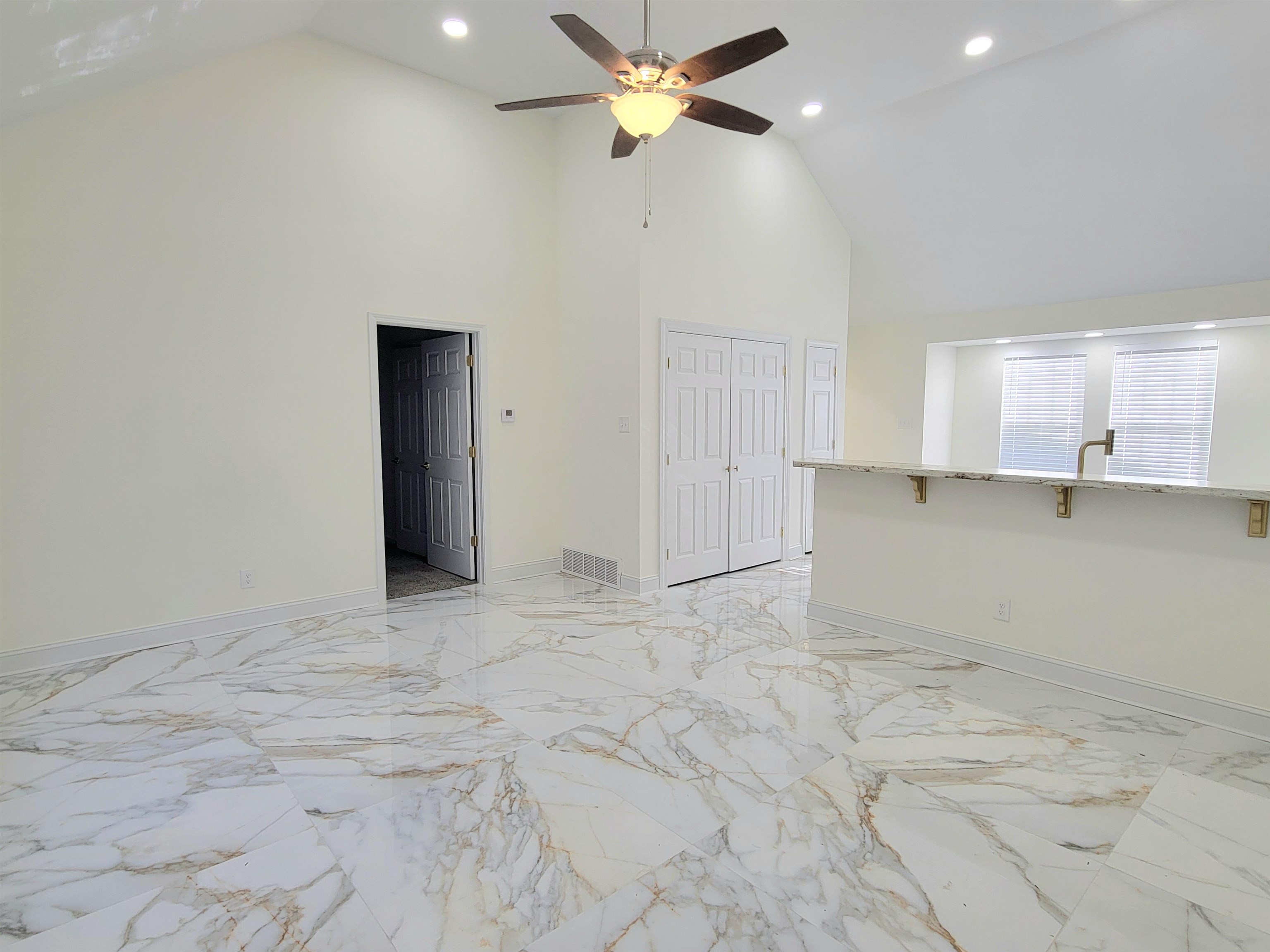 251 East Mitchell Road Memphis, TN 38109 - Photo 4 of 24 Unfurnished living room featuring ceiling fan and high vaulted ceiling