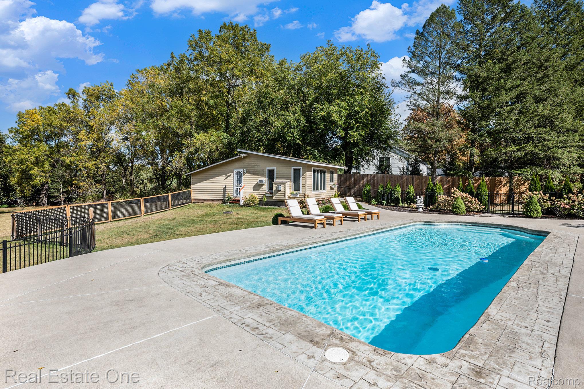 5772 North Rochester Road Rochester, MI 48306 - Photo 6 of 50 View of swimming pool with a fenced backyard, a patio area, view of wooded area, and an outdoor structure