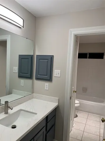 a bathroom with a sink a toilet a shower and a mirror
