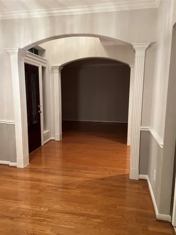 a view of empty room with wooden floor and entryway